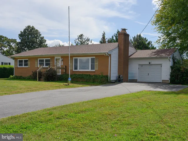 a view of a house with a backyard and a tree