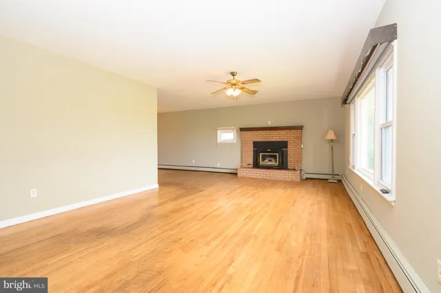 a view of an empty room with a fireplace and a window