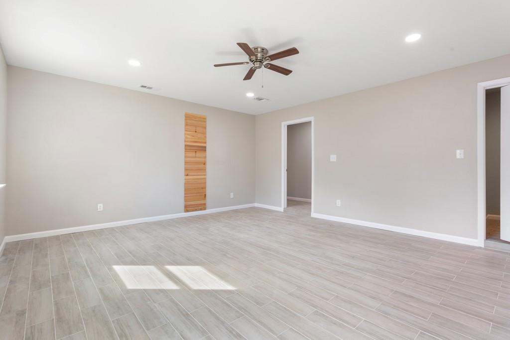 9604 Crown Ridge Road Austin, TX 78753 - Photo 20 of 24 A spacious room offers light-colored plank flooring and a modern ceiling fan for comfort.