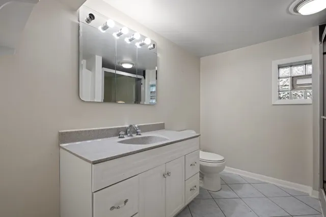 a bathroom with a toilet a sink and mirror