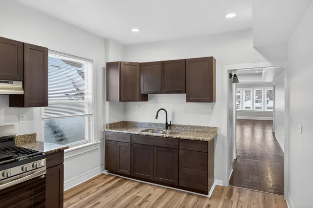 a kitchen with a sink a stove and cabinets