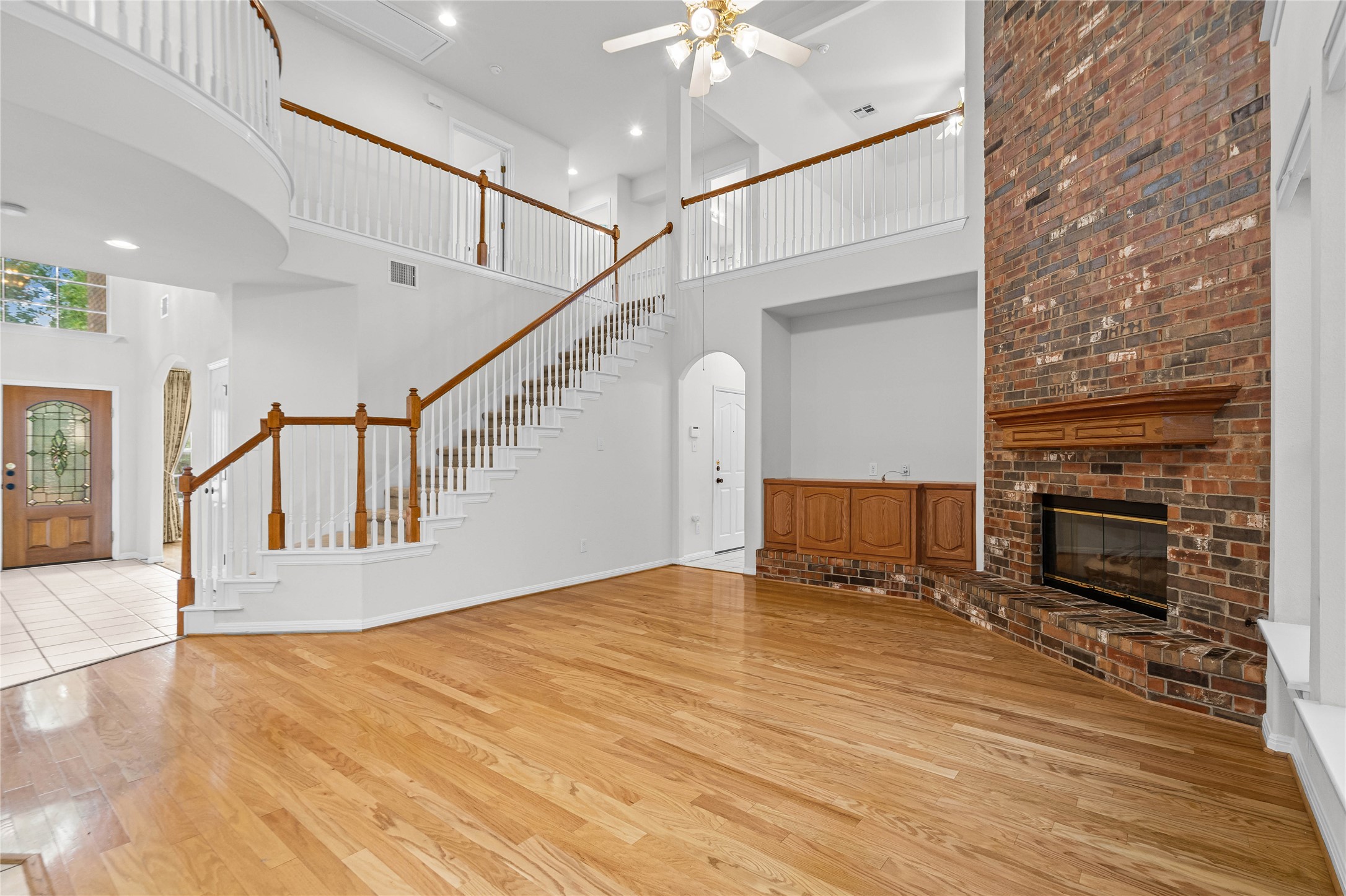 10700 Pointe View Drive Austin, TX 78738 - Photo 8 of 35 A grand living area features rich hardwood flooring, a striking brick fireplace, and an elegant staircase.