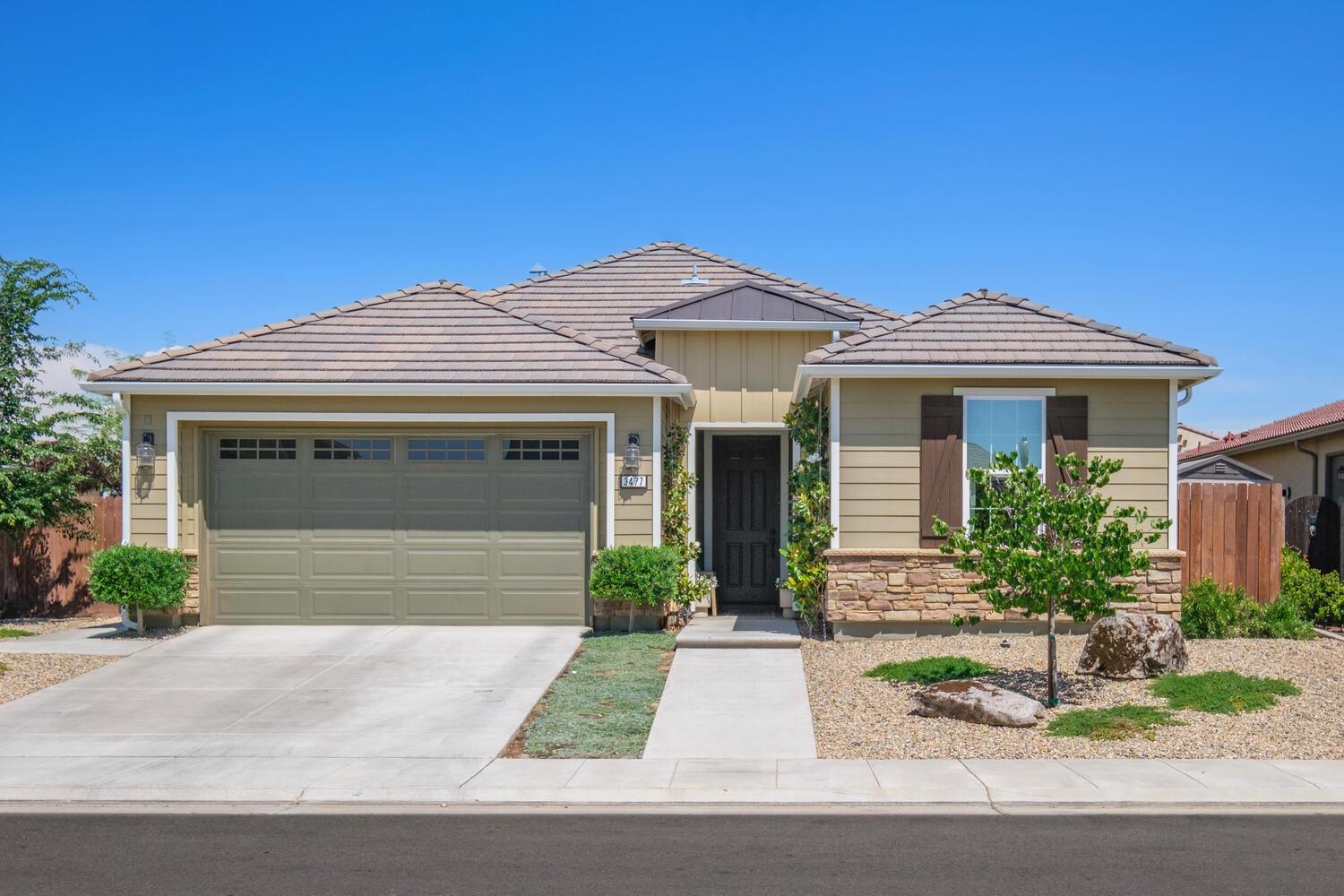 3477 Junipero Avenue Clovis, CA 93619 - Photo 3 of 39 a front view of a house with a yard and garage