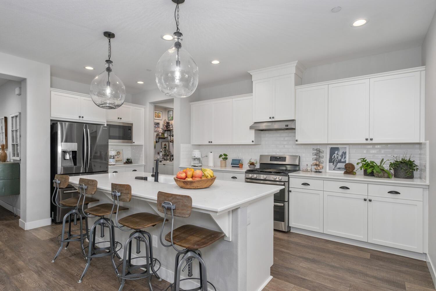 3477 Junipero Avenue Clovis, CA 93619 - Photo 10 of 39 a kitchen with stainless steel appliances a table chairs stove and cabinets