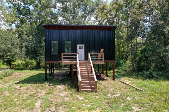 a view of a chair and table in backyard of the house