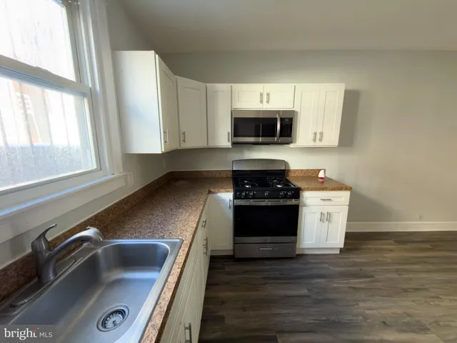 a kitchen with stainless steel appliances granite countertop a sink and a stove top oven