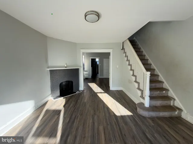 a view of a livingroom with wooden floor and a fireplace