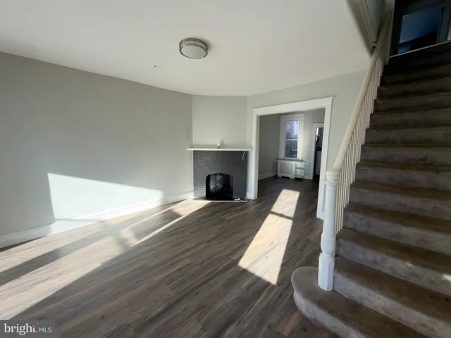 a view of a livingroom with wooden floor and a fireplace