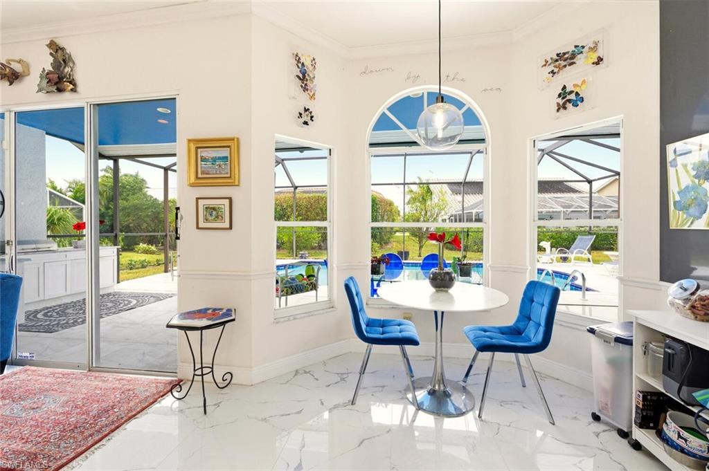 209 Countryside Drive Naples, FL 34104 - Photo 12 of 50 Dining area with a sunroom, ornamental molding, light marble finish floors, and healthy amount of natural light