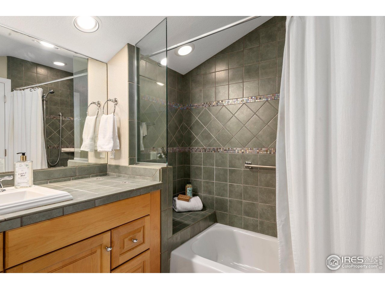 1490 Periwinkle Drive Boulder, CO 80304 - Photo 18 of 25 a bathroom with a granite countertop sink a mirror and a shower