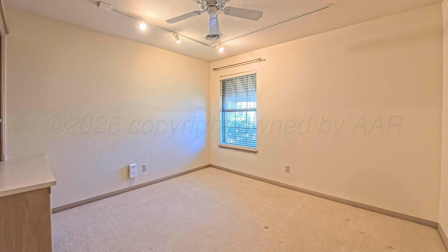 4311 Arp Place Amarillo, TX 79109 - Photo 21 of 36 an empty room with a chandelier fan and windows