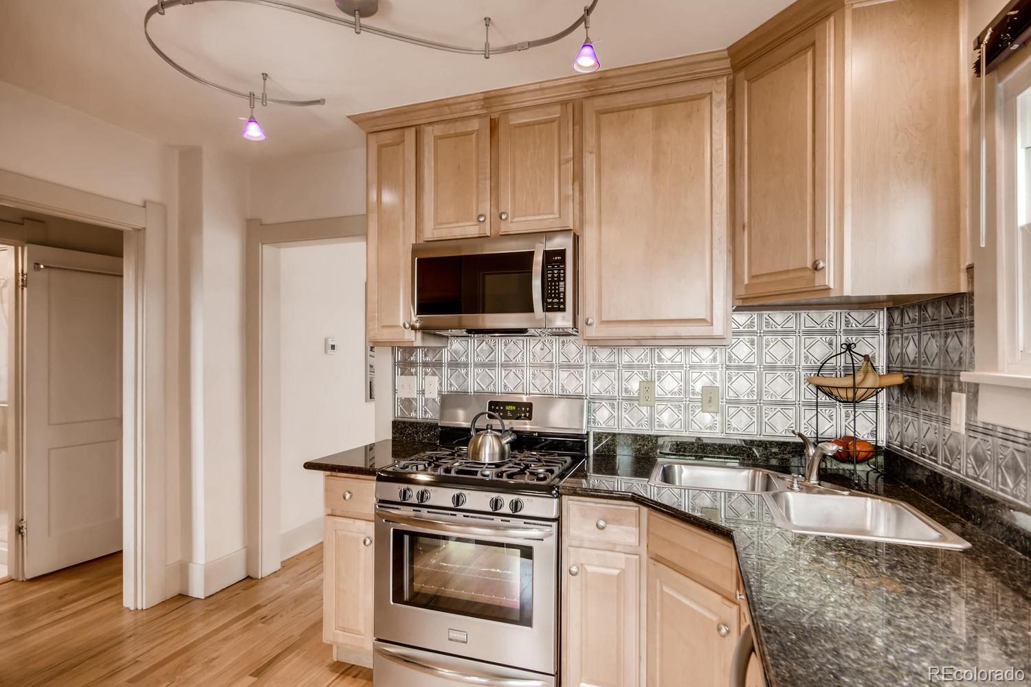 777 South Sherman Street Denver, CO 80209 - Photo 12 of 35 a kitchen with stainless steel appliances a stove a sink and a microwave