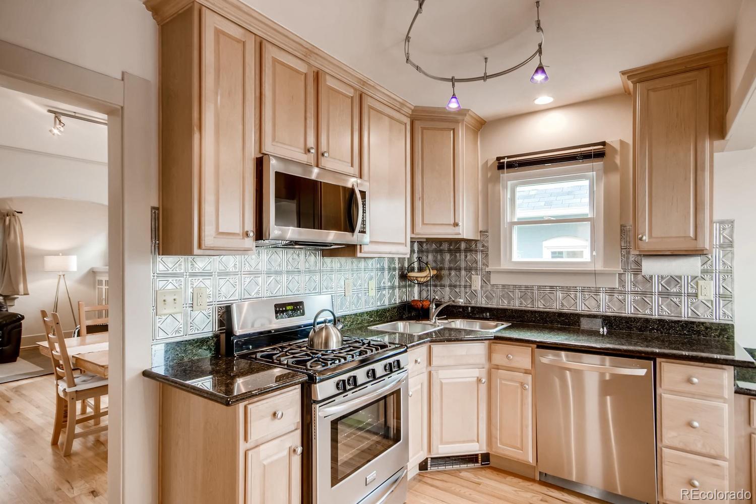 777 South Sherman Street Denver, CO 80209 - Photo 13 of 35 a kitchen with stainless steel appliances granite countertop a stove a sink and a microwave