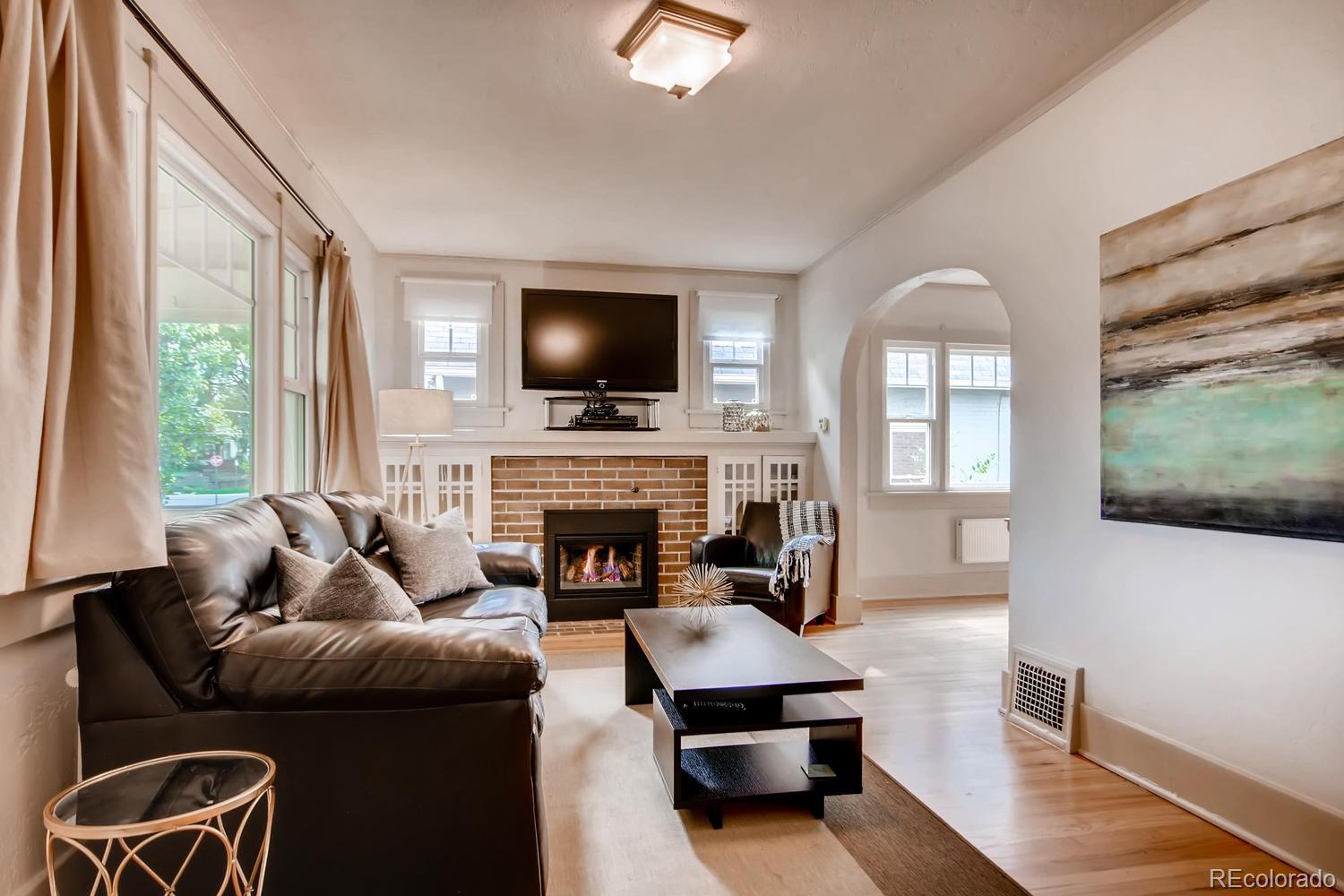 777 South Sherman Street Denver, CO 80209 - Photo 4 of 35 a living room with furniture a fireplace and a flat screen tv