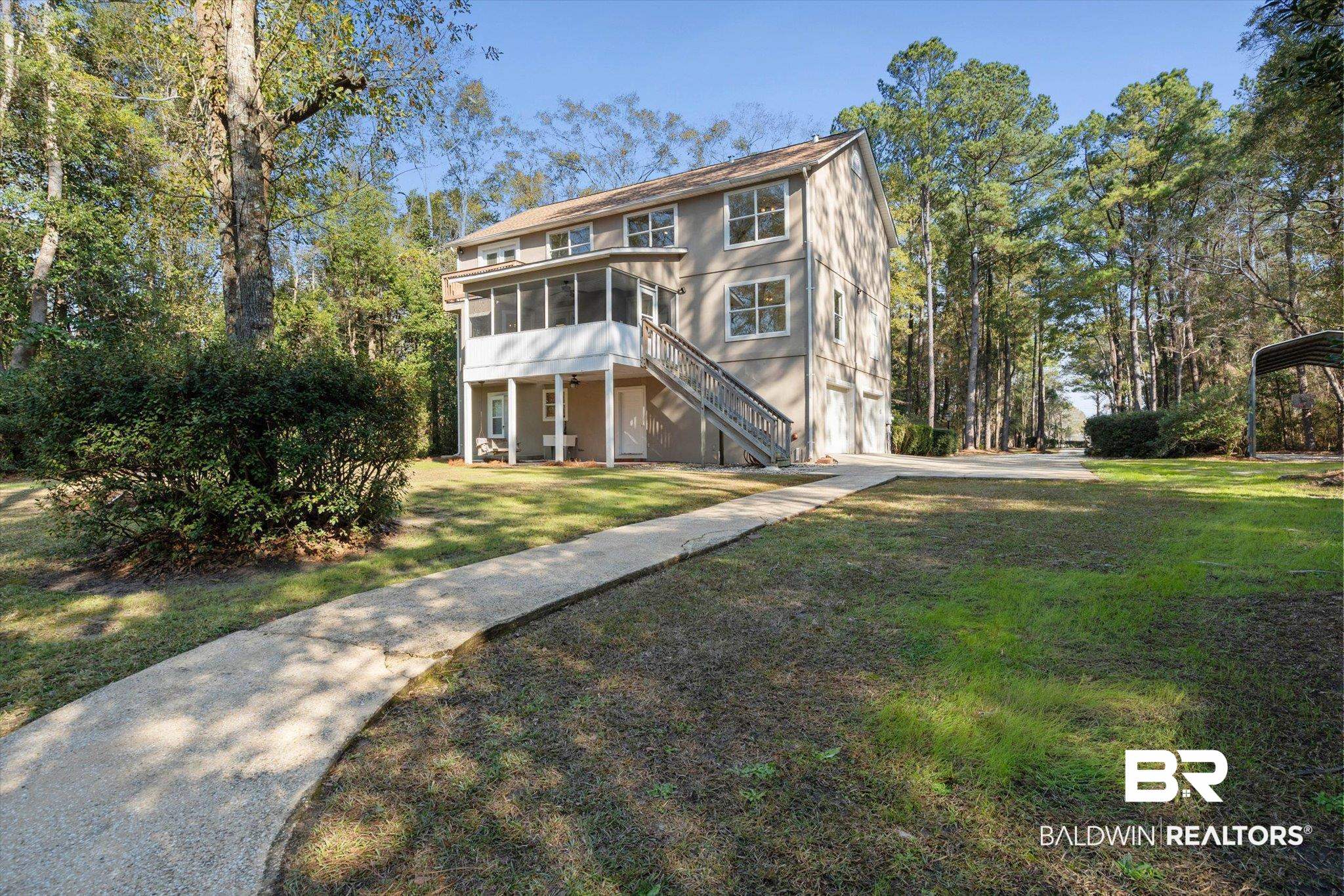 3847 Riviere Du Chien Road Mobile, AL 36693 - Photo 35 of 51 View of front facade with a sunroom, a front lawn, view of scattered trees, and a carport