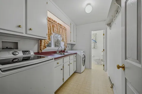 a kitchen with stainless steel appliances a sink a stove a refrigerator and cabinets