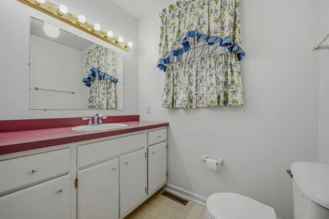a bathroom with a toilet sink and mirror