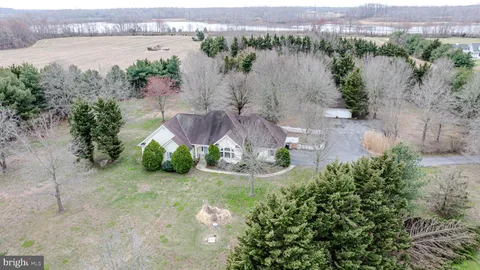 an aerial view of a house with a yard and lake view