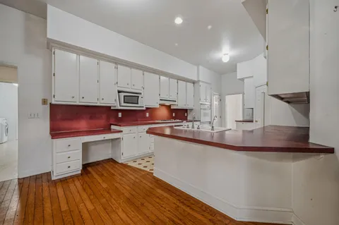 a kitchen with sink cabinets and wooden floor