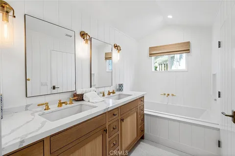 a bathroom with a tub sink and mirror