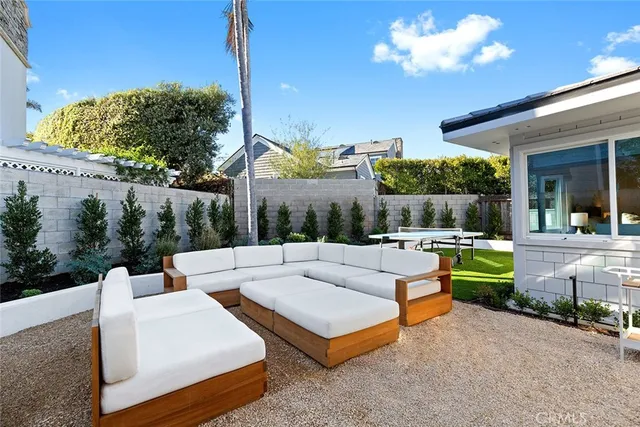 a view of a patio with couches table and chairs with wooden fence