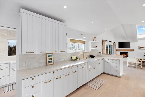 a large white kitchen with stainless steel appliances granite countertop a sink and cabinets
