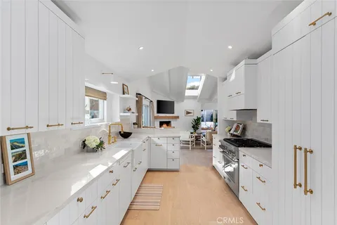 a large white kitchen with lots of counter top space a sink and appliances