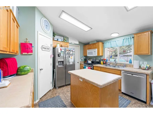 a kitchen with granite countertop a sink stove and refrigerator