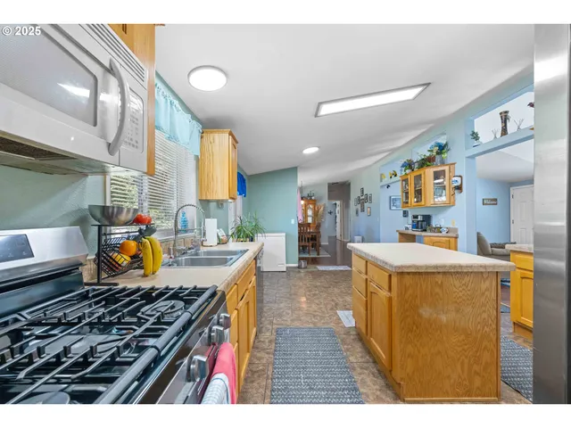 a kitchen with stainless steel appliances granite countertop a stove a sink and a refrigerator