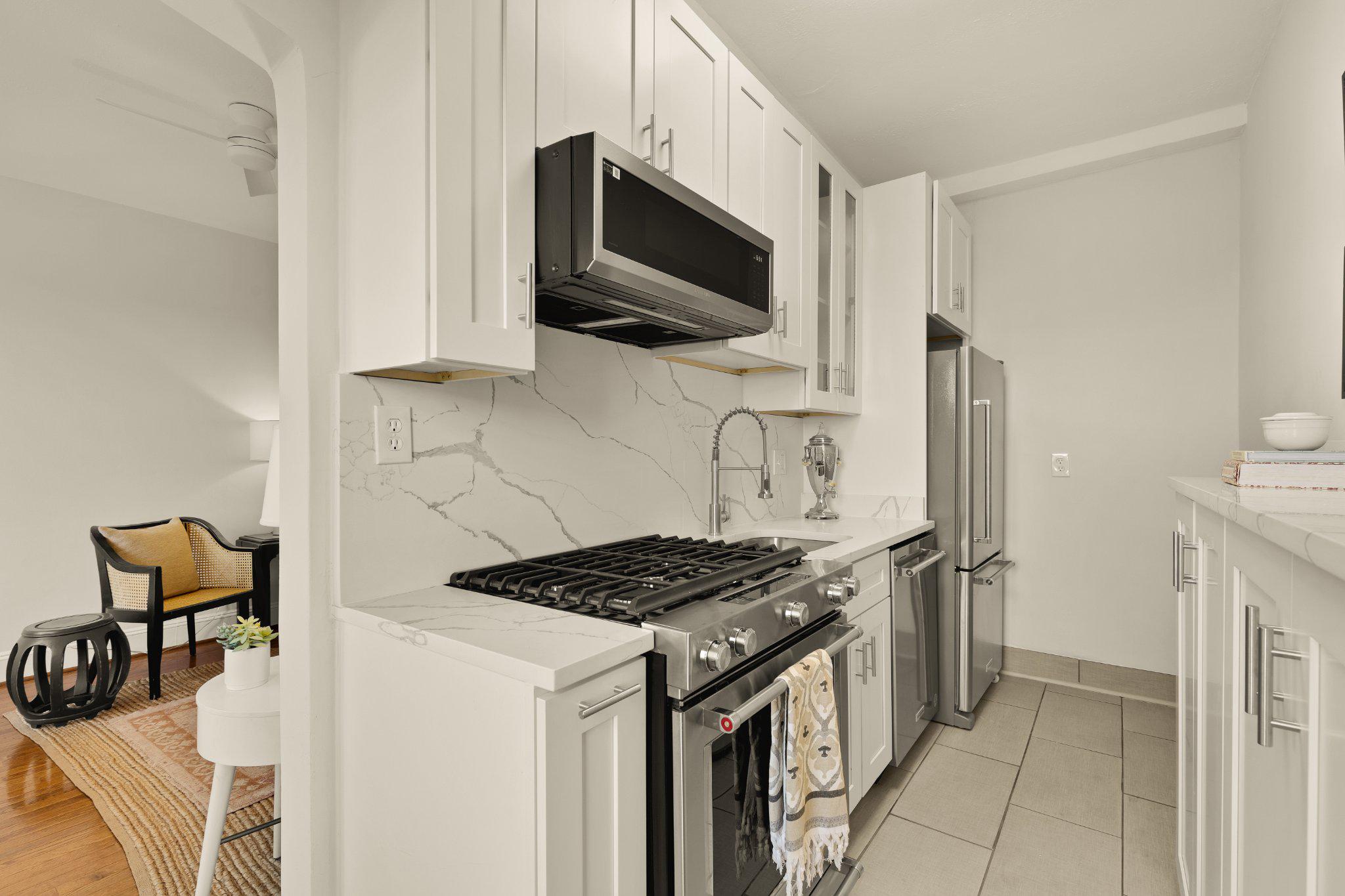 644 Massachusetts Avenue Northeast, Unit 400 Washington, DC 20002 - Photo 12 of 24 a kitchen with stainless steel appliances a stove a microwave and a refrigerator