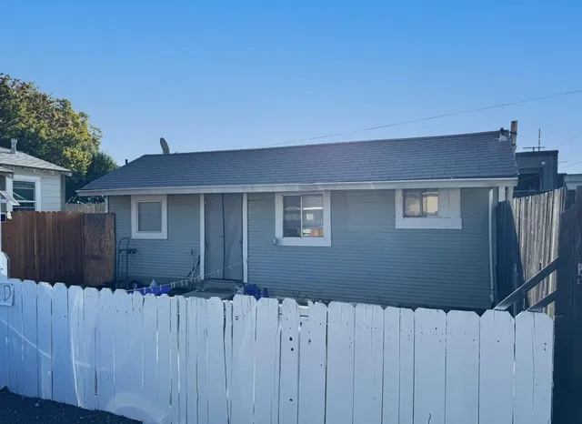 a front view of a house with wooden fence