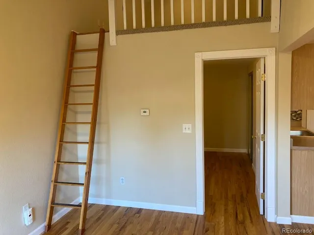 hallway with view of wooden floor and cabinet