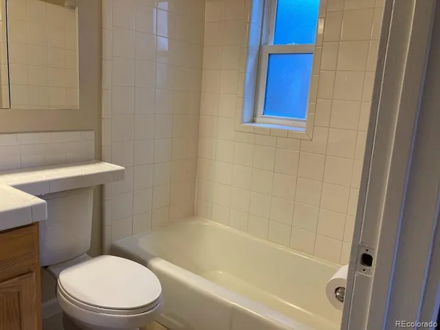 a white toilet sitting next to a bath tub