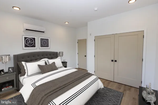 a bedroom with bed and wooden floor