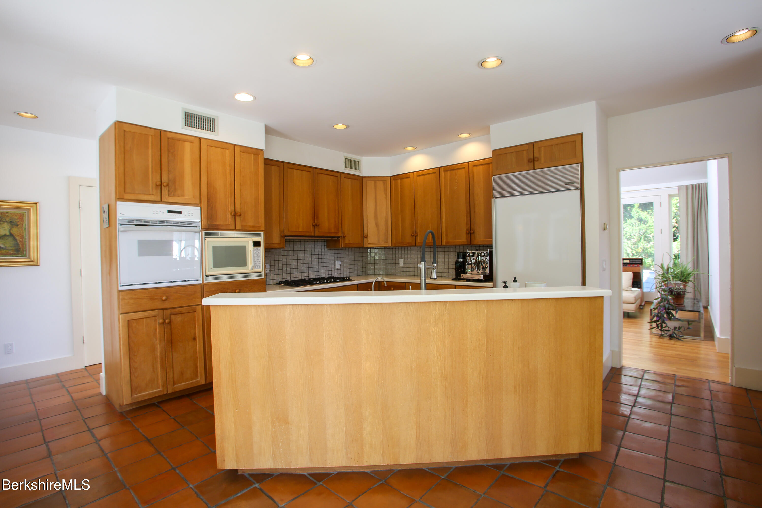 240 Beldingville Road Ashfield, MA 01330 - Photo 18 of 45 a large kitchen with stainless steel appliances a large counter top a stove a microwave a sink a refrigerator and cabinets