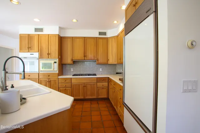 a kitchen with wooden cabinets a sink and a stove