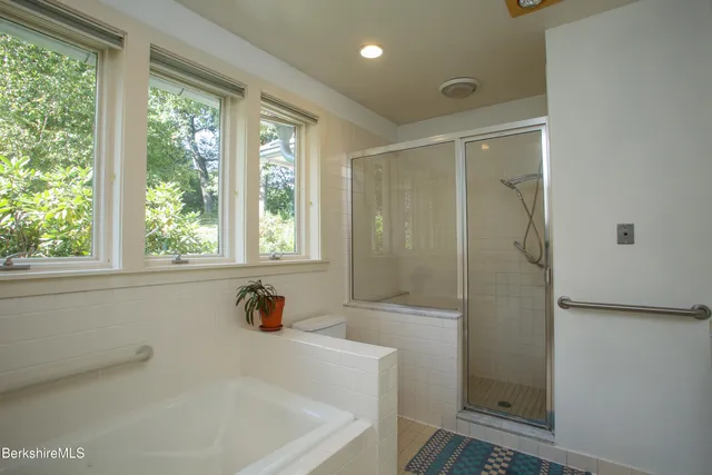 a bathroom with a tub a window and a shower