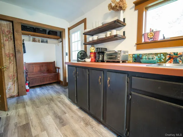 a view of a two room with wooden floor and furniture