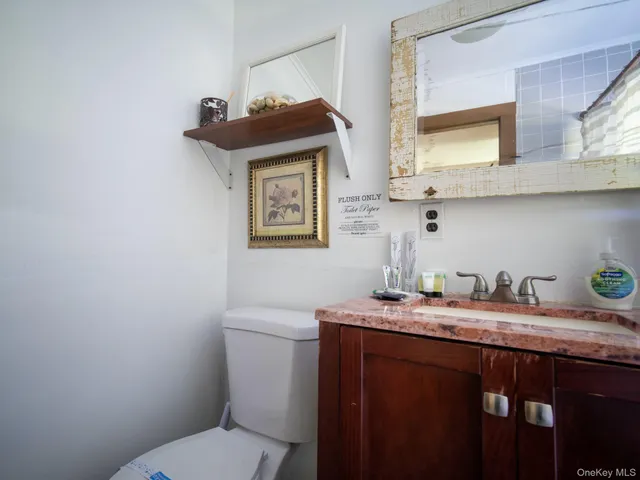 a bathroom with a granite countertop sink a mirror and toilet