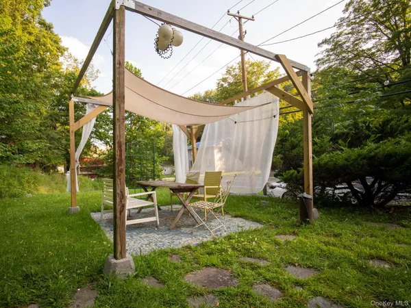 a view of backyard with a table and chairs and floor to ceiling window