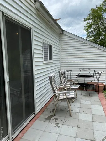 a view of a patio with table and chairs and couches with wooden floor and fence