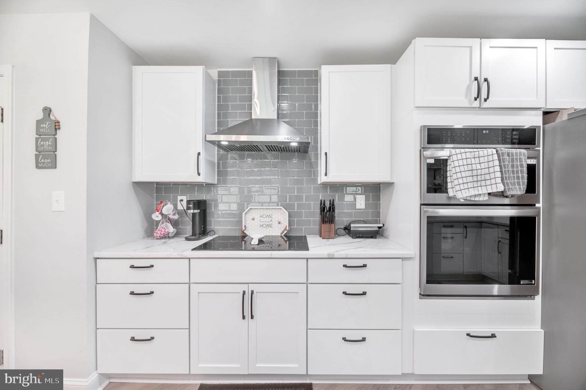 8812 Churchfield Lane Laurel, MD 20708 - Photo 4 of 31 a kitchen with white cabinets and appliances
