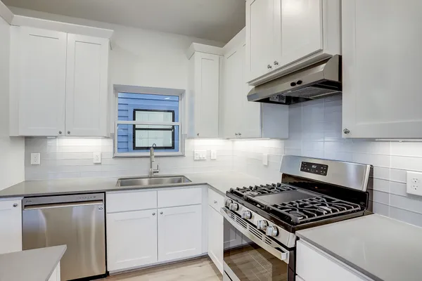 a kitchen with stainless steel appliances a sink dishwasher and stove