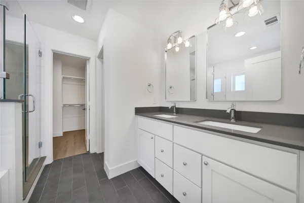 a bathroom with double sink and a mirror