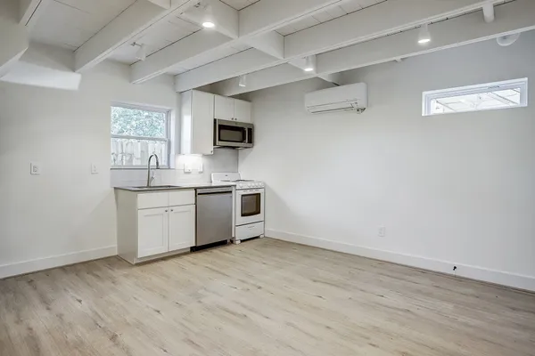 a kitchen with a sink cabinets and wooden floor