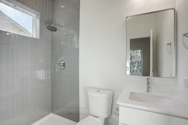 a bathroom with a toilet sink shower and mirror