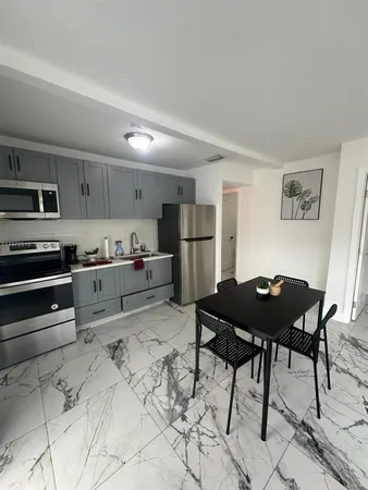 a kitchen with a table chairs refrigerator and cabinets