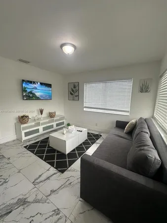 a living room with furniture a rug and a window