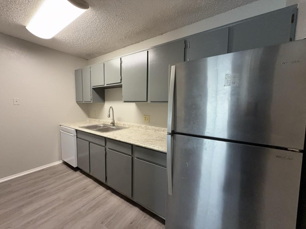 219 Fry Street, Unit 6 Denton, TX 76201 - Photo 7 of 13 a kitchen with stainless steel appliances a refrigerator and a sink