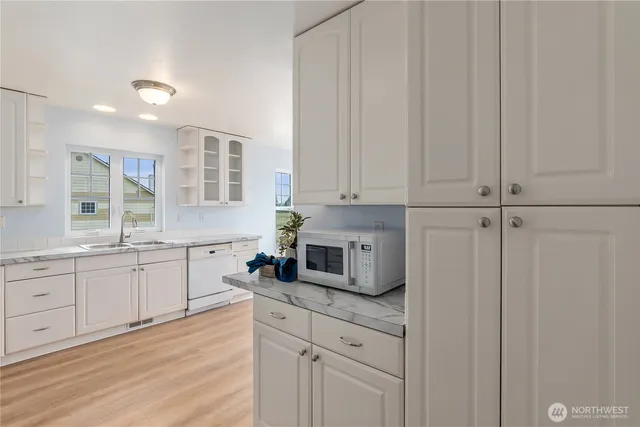 a kitchen with granite countertop white cabinets and white appliances